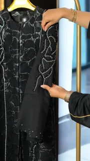 مانتو عبایی مشکی با پارچه براق طرحدار، سنگ‌دوزی دستی روی آستین و جلو، مناسب سایز ۳۸ تا ۵۰