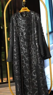 مانتو عبایی مشکی با پارچه براق طرحدار، سنگ‌دوزی دستی روی آستین و جلو، مناسب سایز ۳۸ تا ۵۰