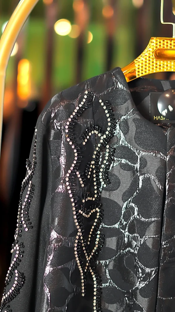 مانتو عبایی مشکی با پارچه براق طرحدار، سنگ‌دوزی دستی روی آستین و جلو، مناسب سایز ۳۸ تا ۵۰