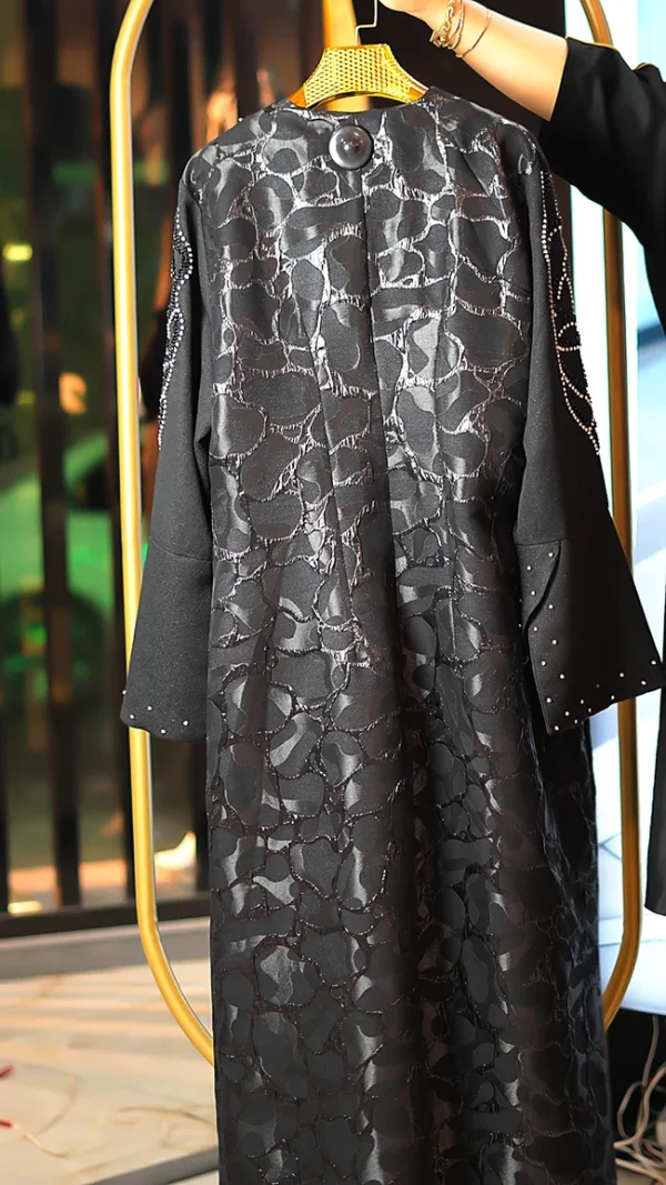 مانتو عبایی مشکی با پارچه براق طرحدار، سنگ‌دوزی دستی روی آستین و جلو، مناسب سایز ۳۸ تا ۵۰