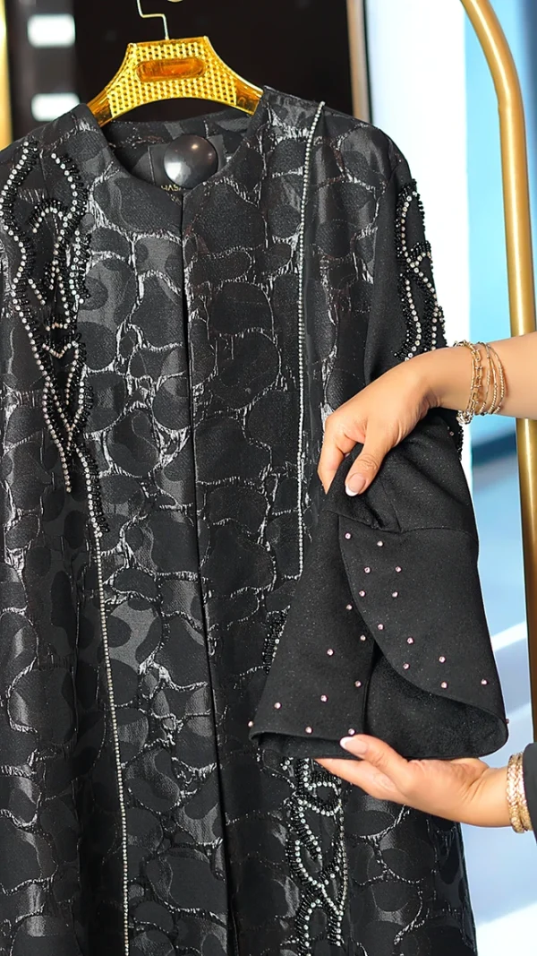 مانتو عبایی مشکی با پارچه براق طرحدار، سنگ‌دوزی دستی روی آستین و جلو، مناسب سایز ۳۸ تا ۵۰