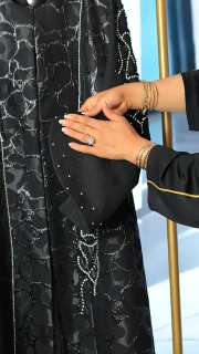 مانتو عبایی مشکی با پارچه براق طرحدار، سنگ‌دوزی دستی روی آستین و جلو، مناسب سایز ۳۸ تا ۵۰